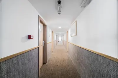 a hallway in a building with white walls and a long corridor at Botel Racek in Prague