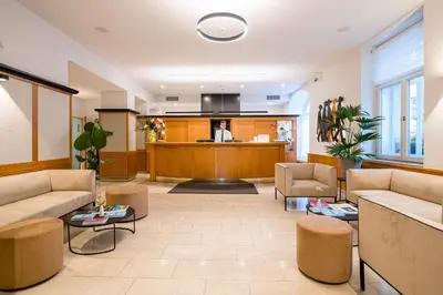 a hotel room with two beds and a desk at Best Western Hotel Moran in Prague