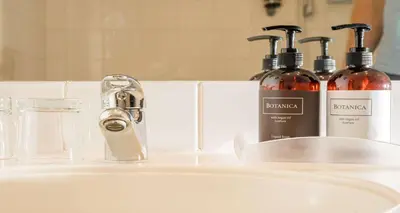 a bathroom sink with two bottles of alcohol on it at Best Western Hotel Moran in Prague