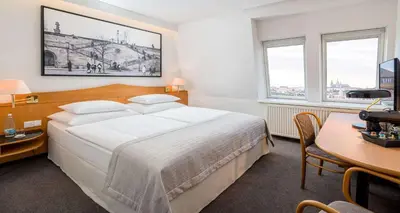 a hotel room with two beds and a table at Best Western Hotel Moran in Prague