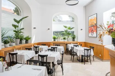 a restaurant with two tables with white tablecloths at Best Western Hotel Moran in Prague