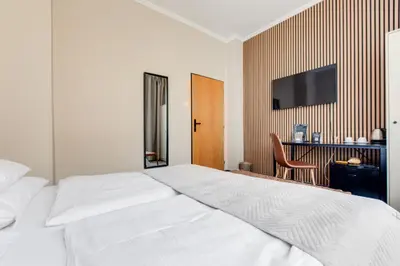 a bedroom with a white bed and a chair at Hotel Andante in Prague