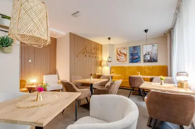 a restaurant with tables and chairs and a chandelier at Hotel Andante in Prague