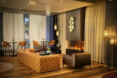 a living room with a couch and a fireplace at Diplomat Hotel Prague in Prague