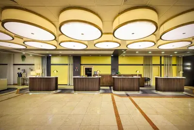 a lobby with a large ceiling with circular lights at Diplomat Hotel Prague in Prague