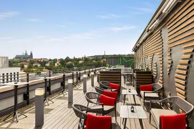 a balcony with tables and chairs on a building at Diplomat Hotel Prague in Prague