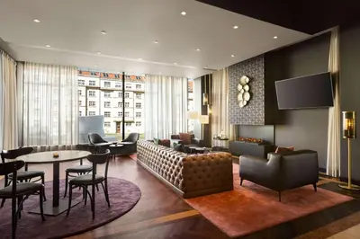 a living room with a couch and a table and chairs at Diplomat Hotel Prague in Prague