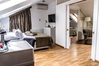 a bedroom with a bed and a living room at Hotel Julian in Prague