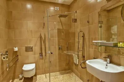 a bathroom with a shower and a toilet and a sink at Hotel Julian in Prague