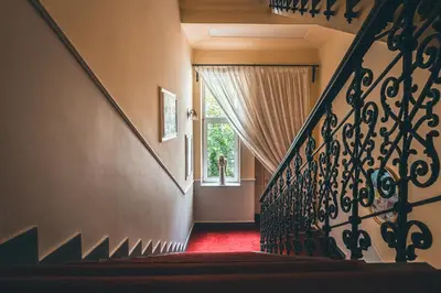 a staircase with a red carpet and a window at Hotel Julian in Prague