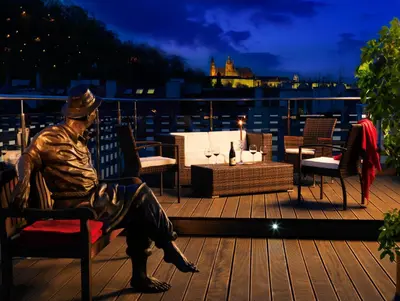 a statue of a man sitting on a bench on a deck at Hotel Julian in Prague