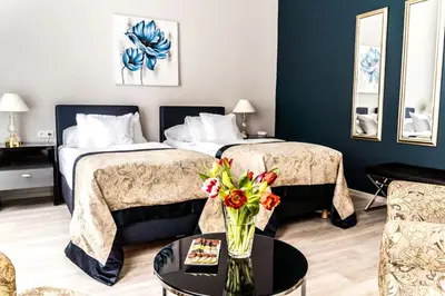 a hotel room with two beds and a table with flowers at Hotel Julian in Prague