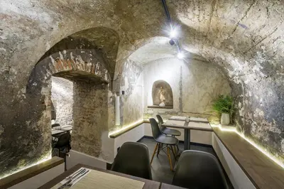 a room with a table and chairs in a stone building at Hotel Waldstein in Prague