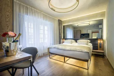 a bedroom with a bed and a table and a desk at Hotel Waldstein in Prague
