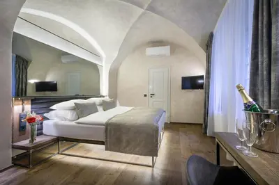 a bedroom with a bed and a bottle of champagne at Hotel Waldstein in Prague