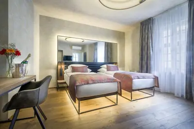 a hotel room with two beds and a mirror at Hotel Waldstein in Prague