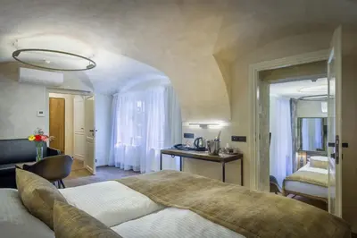 a hotel room with a large bed and a bathroom at Hotel Waldstein in Prague