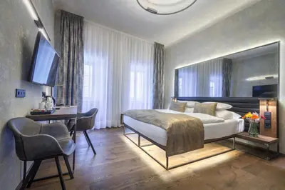 a bedroom with a large bed and a desk with a computer at Hotel Waldstein in Prague