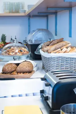 a counter with baskets of bagels and bread on it at Hotel Meda of Museum Kampa in Prague