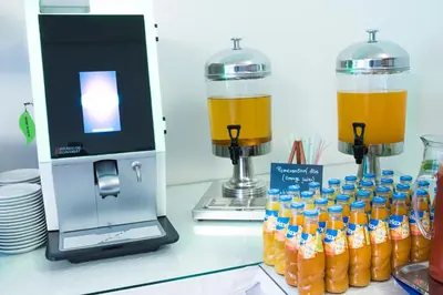 a group of bottles of orange juice next to a juicer at Hotel Meda of Museum Kampa in Prague