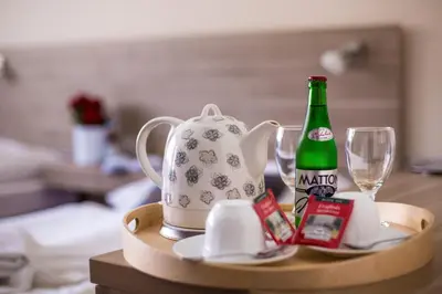 a table with a tea kettle and a bottle of alcohol at Hotel Meda of Museum Kampa in Prague