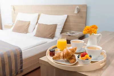a tray with breakfast foods on a bed at Hotel Meda of Museum Kampa in Prague