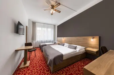 a hotel room with two beds and a ceiling fan at Hotel Meda of Museum Kampa in Prague