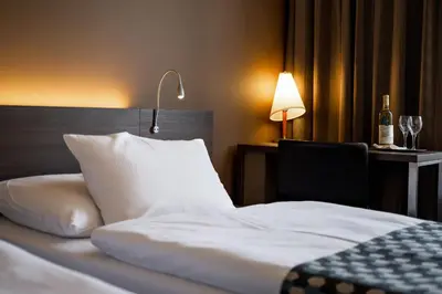 a bedroom with a bed with a lamp and a bottle of wine at Expo Hotel in Prague