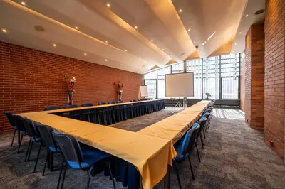 a conference room with tables and chairs and a screen at Expo Hotel in Prague