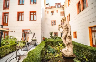 a statue in a garden in front of a building at Hotel Elite Prague in Prague