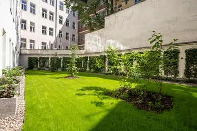 a garden with green grass and a building at K+K Hotel Fenix in Prague