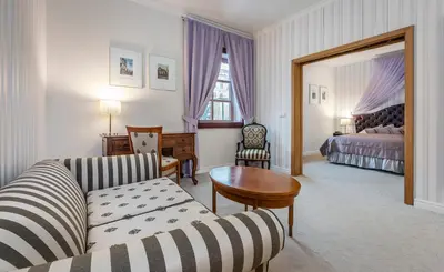 a bedroom with a large bed with a purple canopy at Hotel Hoffmeister in Prague