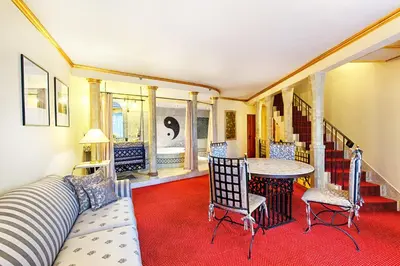 a bedroom with a bed with two chairs and a table at Hotel Hoffmeister in Prague