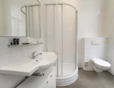 a white bathroom with a sink and a shower at Hotel Adler - Czech Leading Hotels in Prague