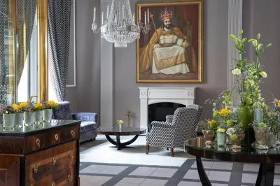 a living room with a painting of a woman at Grand Hotel Bohemia in Prague