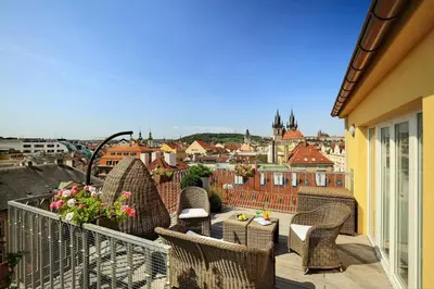a balcony with wicker chairs and a view of a city at Grand Hotel Bohemia in Prague