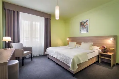 a hotel room with a bed and a desk and a window at Atlantic Hotel in Prague