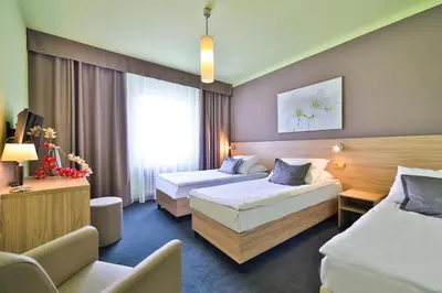 a hotel room with two beds and a couch at Atlantic Hotel in Prague