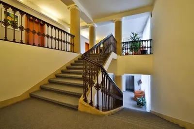 a winding staircase in a home with yellow walls at Atlantic Hotel in Prague