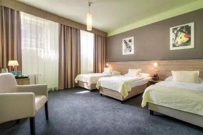 a hotel room with two beds and a chair at Atlantic Hotel in Prague