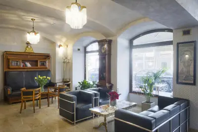 a living room with couches and a table and chairs at Hotel Mucha in Prague