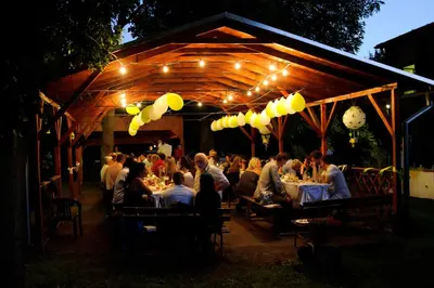a group of people sitting at tables at a restaurant at night at Hotel Grand in Řevnice
