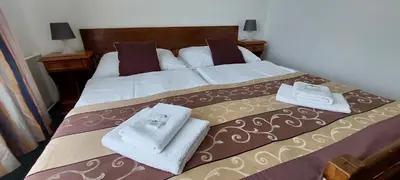 a bedroom with a bed with towels on it at Hotel Grand in Řevnice