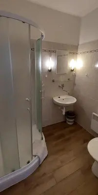 a bathroom with a shower and a sink at Hotel Grand in Řevnice