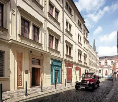an old car parked on a street next to a building at The Charles in Prague