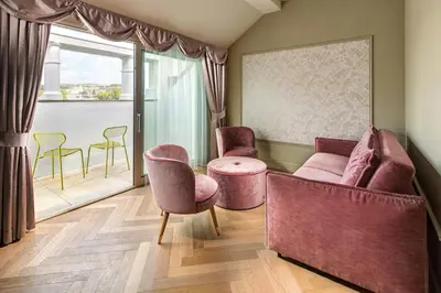 a waiting room with pink chairs and a window at Mamaison Hotel Riverside Prague in Prague