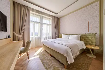 a hotel room with a bed and a desk and a window at Mamaison Hotel Riverside Prague in Prague