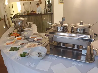 a buffet table with food on it with pots and pans at Hotel Metamorphis in Prague