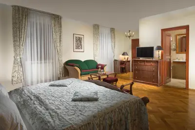 a bedroom with a bed and a tv and a couch at Boutique Hotel Constans in Prague