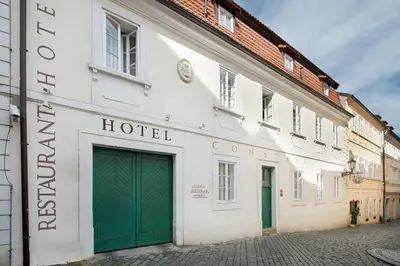 a white building with green doors on a street at Boutique Hotel Constans in Prague